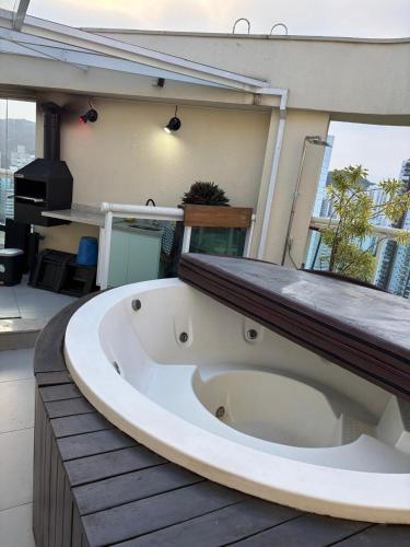 a large white bath tub sitting on a balcony at Santos Unique 2701 Jacuzzi & Sea View Duplex in Santos