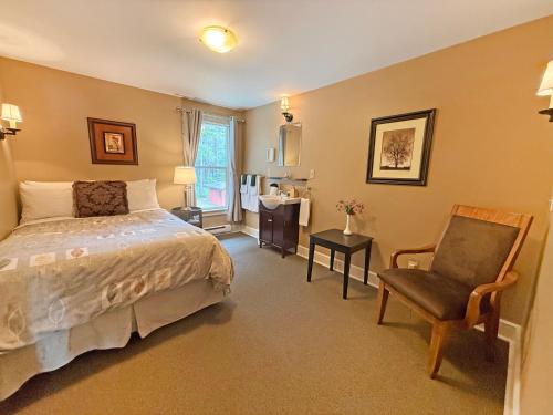 ein Schlafzimmer mit einem Bett und einem Stuhl in der Unterkunft Dragon's Lodge in Gabriola