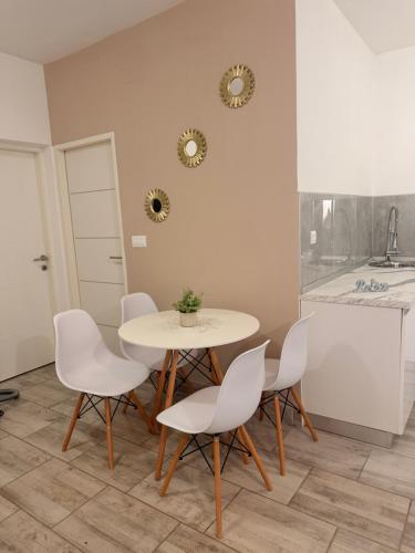 a dining room with a white table and chairs at Lalya App in Vodnjan