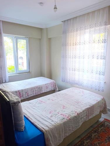 a bedroom with two beds and a window at Murat Kaptan Apt in Gündoğdu