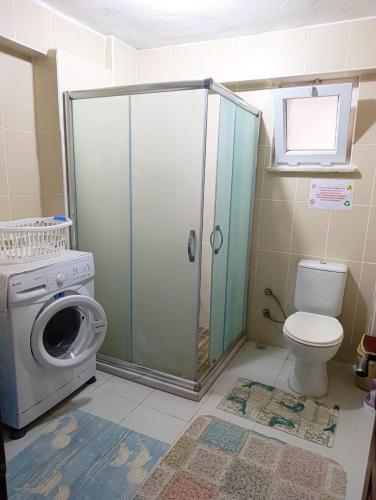 a bathroom with a toilet and a washing machine at Murat Kaptan Apt in Gündoğdu