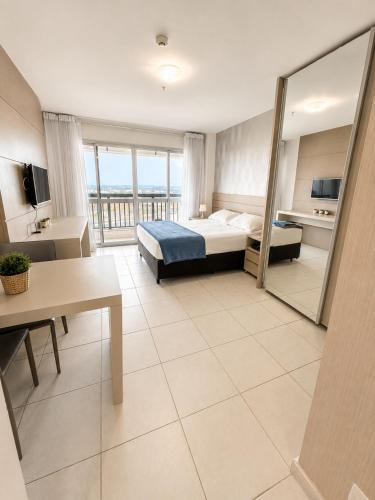 a hotel room with a bed and a balcony at Alugueasy - Hotel Vision in Brasília