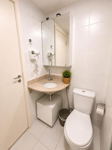 a white bathroom with a toilet and a sink at Alugueasy - Hotel Vision in Brasília