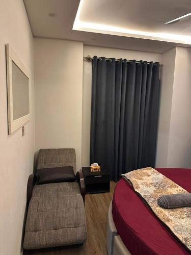 a bedroom with a bed and a black curtain at The crimson round bed luxe suite in Rawalpindi