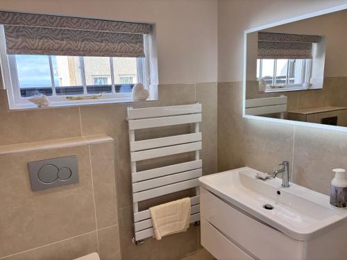 a bathroom with a sink and a mirror at Luxury sea view villa in Ballycastle