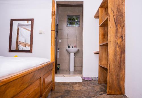 a bathroom with a sink and a mirror at Auregi Villas in Diani Beach