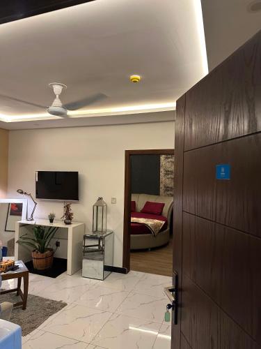 a living room with a couch and a tv at The crimson round bed luxe suite in Rawalpindi