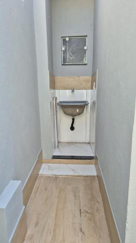 a bathroom with a sink in the corner of a room at Casa Real in Guarapari