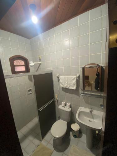 a small bathroom with a toilet and a sink at Pousada Caranã in Salinópolis