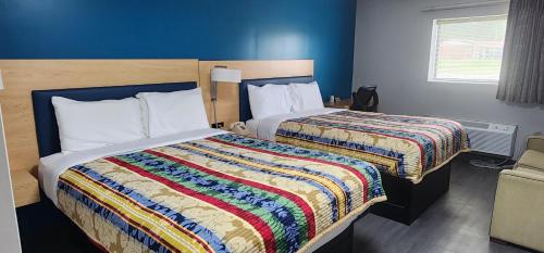 a hotel room with two beds with a colorful blanket at Anchor inn in New Johnsonville