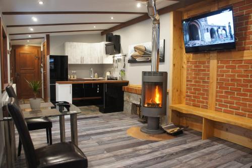 a living room with a fireplace and a kitchen at Góralska Osada Karpacz - Apartametny in Karpacz