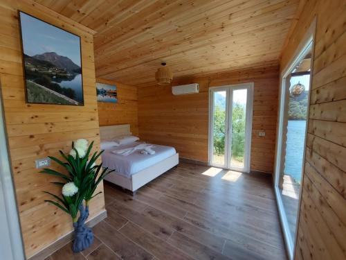 a bedroom in a log cabin with a bed and windows at Villa Sajmo in Koman