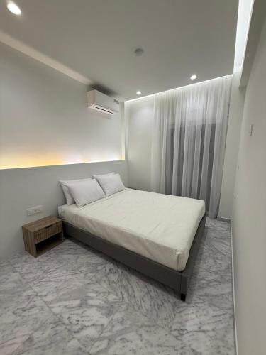 a white bedroom with a bed and a window at Meraki Luxury Retreat in Kos