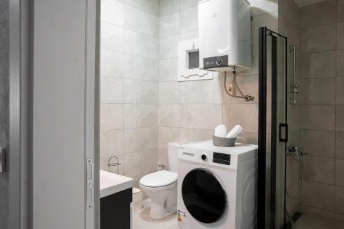 a bathroom with a washing machine and a toilet at Defne House Urla in Urla