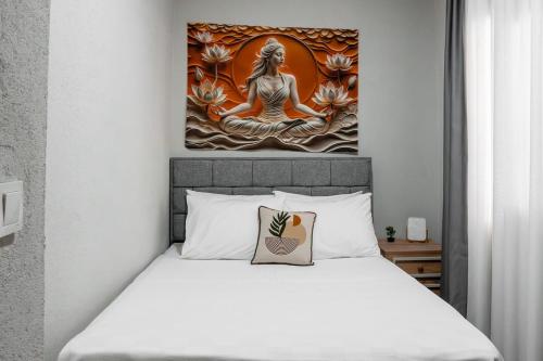 a bedroom with a bed with a painting on the wall at Defne House Urla in Urla