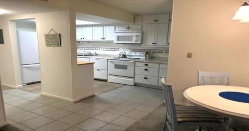 a kitchen with a table and a kitchen with white appliances at Serene Florida Oasis in Inverness