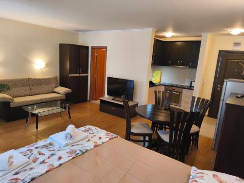 a living room with a bed and a dining room at Апартаменти-Студия в Комплекс Нестинарка in Tsarevo