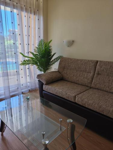 a living room with a couch and a glass table at Апартаменти-Студия в Комплекс Нестинарка in Tsarevo