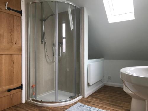 a glass shower in a bathroom with a sink at Bunkers Hill Farm in Bramfield