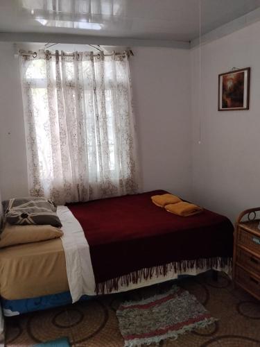 a bed in a room with a window and a bedspread at PlayaMariaChiquita in Colón