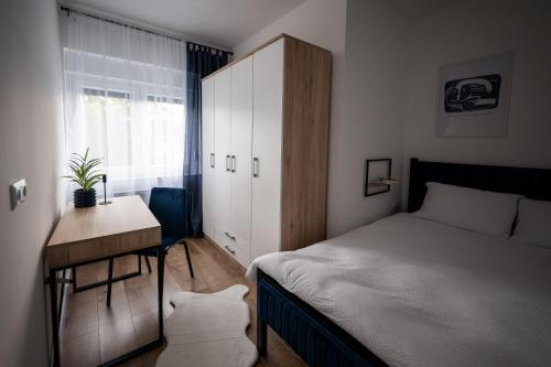 a bedroom with a bed and a desk and a cabinet at Modern Studio Apartment in Žepče