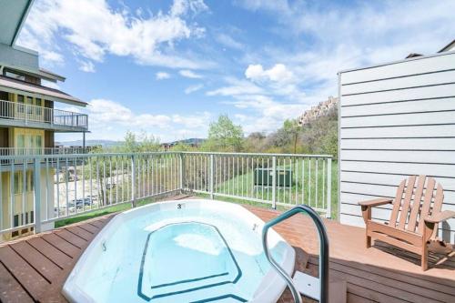 a hot tub sitting on a deck with a chair at Slopeside Chalet in Steamboat Springs