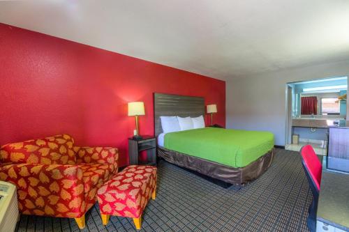 a hotel room with a bed and a chair at The Lodge at the Falls in Wichita Falls