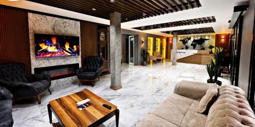 a living room with a couch and a fireplace at Sezgin Hotel in Uzungöl