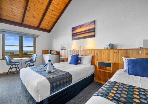 a bedroom with two beds and a table and chairs at Stanley Seaview Inn in Stanley