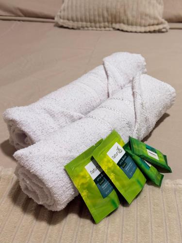 a white towel on the floor with two green products at Apartamento Prático Completo in Goiânia