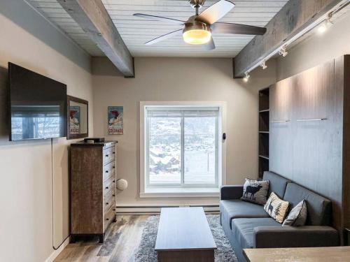 a living room with a couch and a tv at Gondola Heights Hideaway in Steamboat Springs