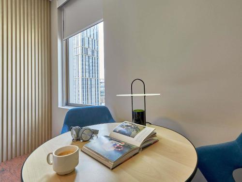 a table with a book and a cup of coffee at ibis Perth in Perth