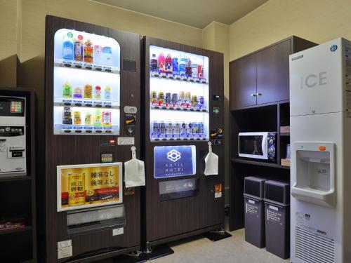 a vending machine with drinks and a tv in a room at Astil Hotel Shinosaka Precious in Osaka