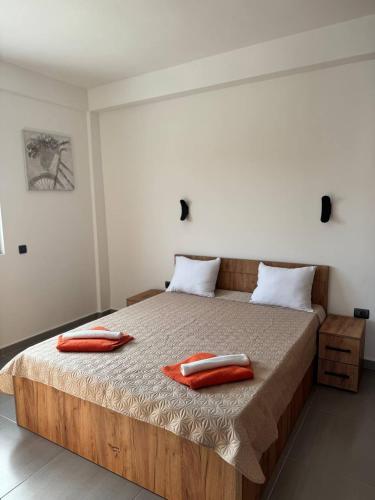 a bed with two red towels on top of it at Bran Apartments in Star Dojran