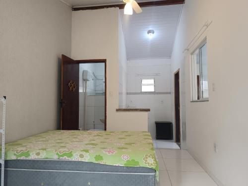 a bedroom with a bed and a shower in it at Casa inteira 4 pessoas, 2 quartos, suite ar, 2 banheiros, home office, estacionamento, próx praia Itaúna in Saquarema