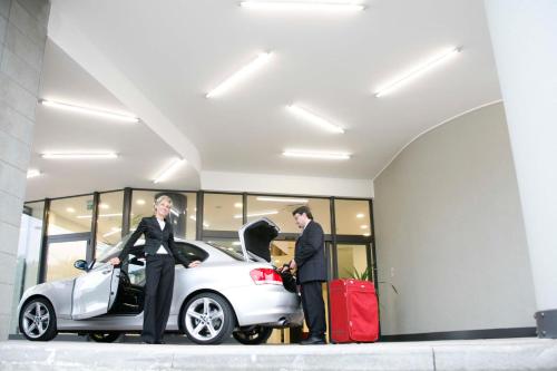two men standing next to a car with luggage at Euro Hotel Residence in Concorezzo