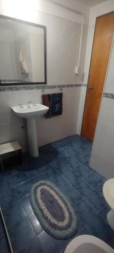 a bathroom with a sink and a mirror and a rug at Chalet del Rio in Cuesta Blanca