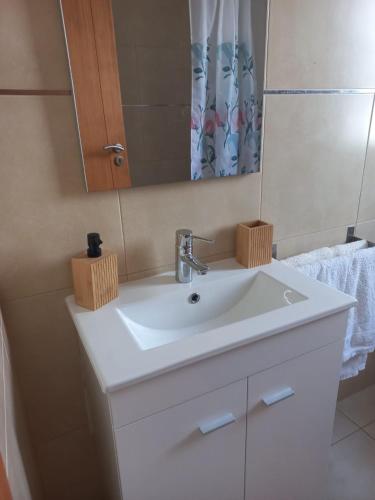 a bathroom with a white sink and a mirror at Maroiço Residence in Madalena