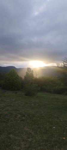 a field with the sun setting in the horizon at Chalet del Rio in Cuesta Blanca