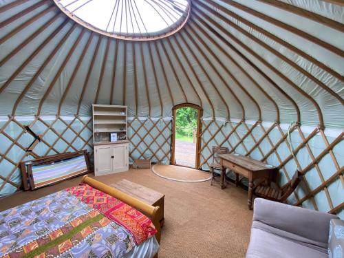 a bedroom in a yurt with a bed and a table at Bunkers Hill Farm in Bramfield