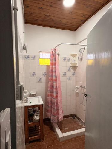 a bathroom with a shower with a pink shower curtain at Villa Valeria in General Acha