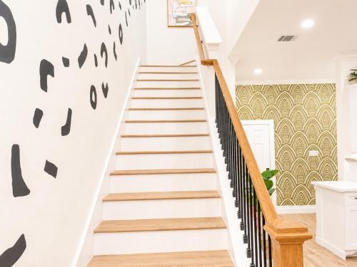 a staircase in a house with white walls and black railings at Downtown Luxe Retreat - King Bed, Pool, Pong, Billiards, Grill & FREE Coffee in Houston