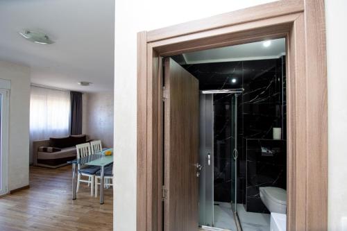 a glass door leading to a living room with a table at Apartmani Čukić Rafailovići in Budva