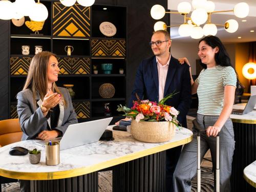 a group of people standing around a table with a laptop at Mercure Lyon Centre Saxe Lafayette in Lyon