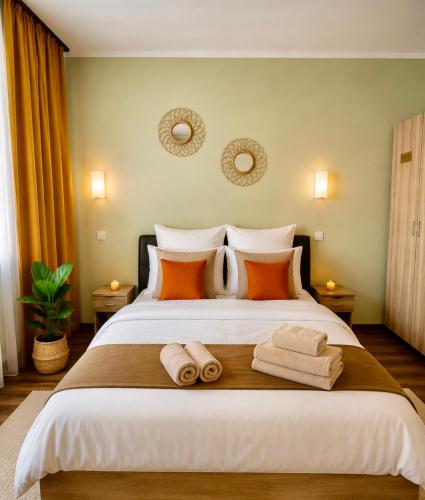 a bedroom with a large bed with towels on it at Ama Residence 1 in Deva