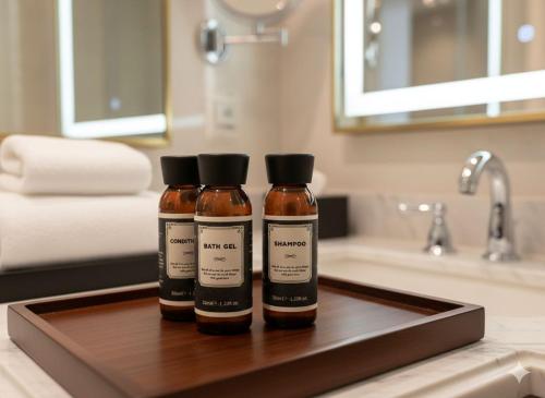 two bottles of honey sitting on a tray in a bathroom at SAkura Hotel Astara in Astara