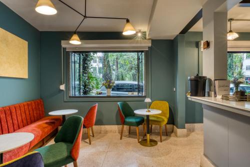 a waiting room with colorful chairs and tables at Casa Altata Hotel Boutique in Mexico City