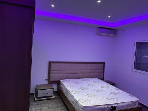 a bedroom with a bed with a purple lighting at Villa cornich in Banzart