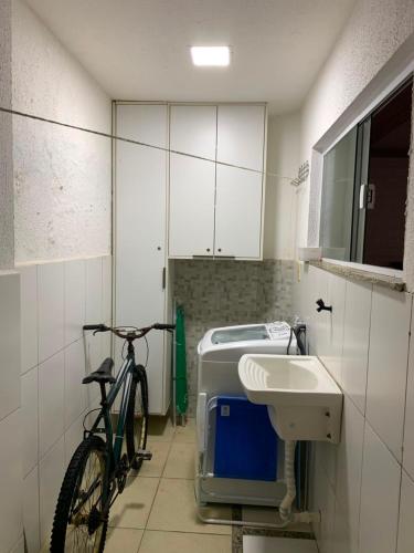 a bike parked in a bathroom with a sink at Casa de Praia - Ipitanga in Lauro de Freitas