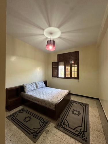 a bedroom with a bed and a window and a ceiling at rez-de-chaussée villa pour famille in Sidi Bouzid
